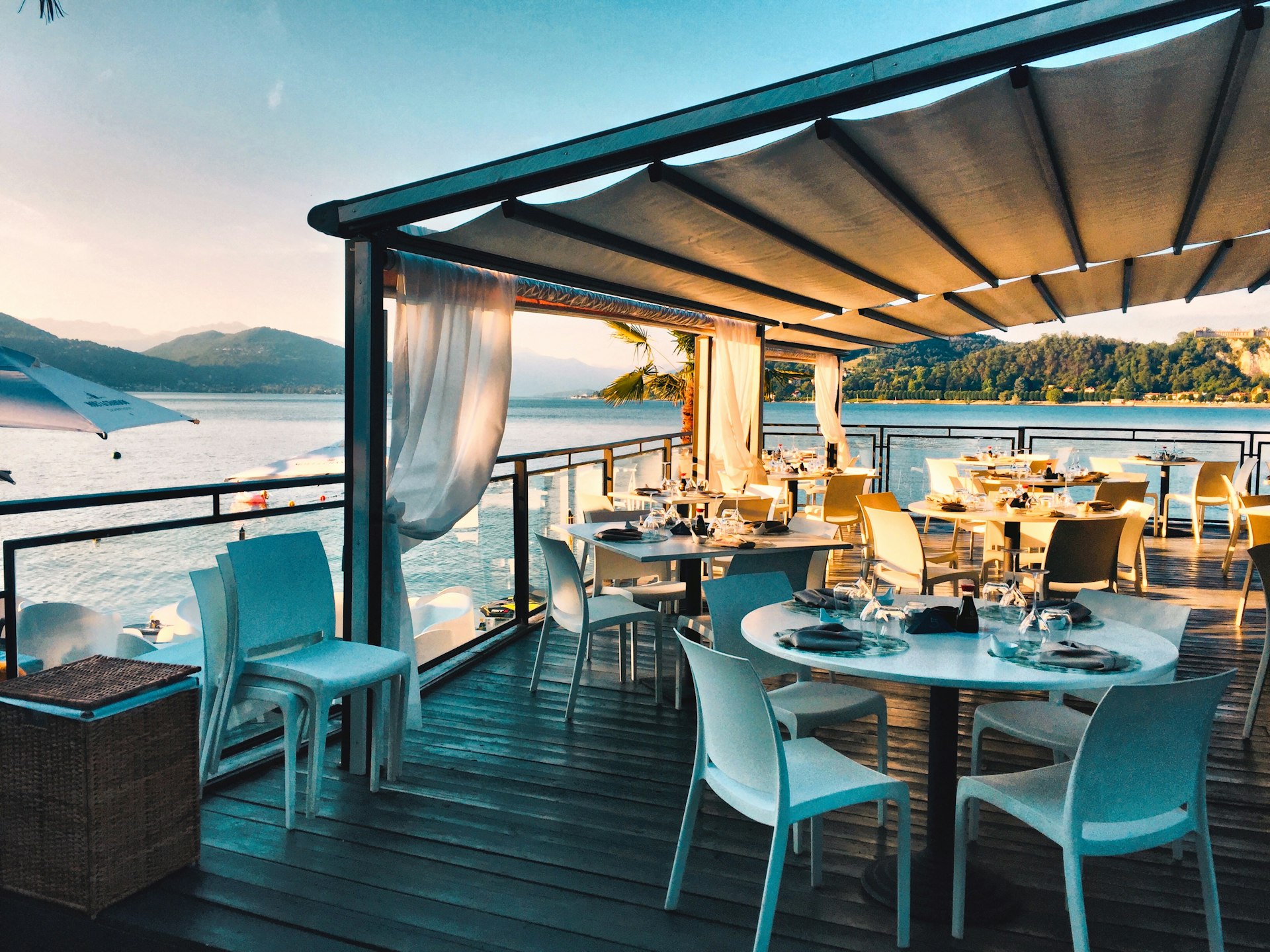 cinematic shot of an upscale mediterranean restaurant interior, earthy tones, olive green velvet chairs, terracotta pots, warm ambient lighting, highly detailed, architectural photography